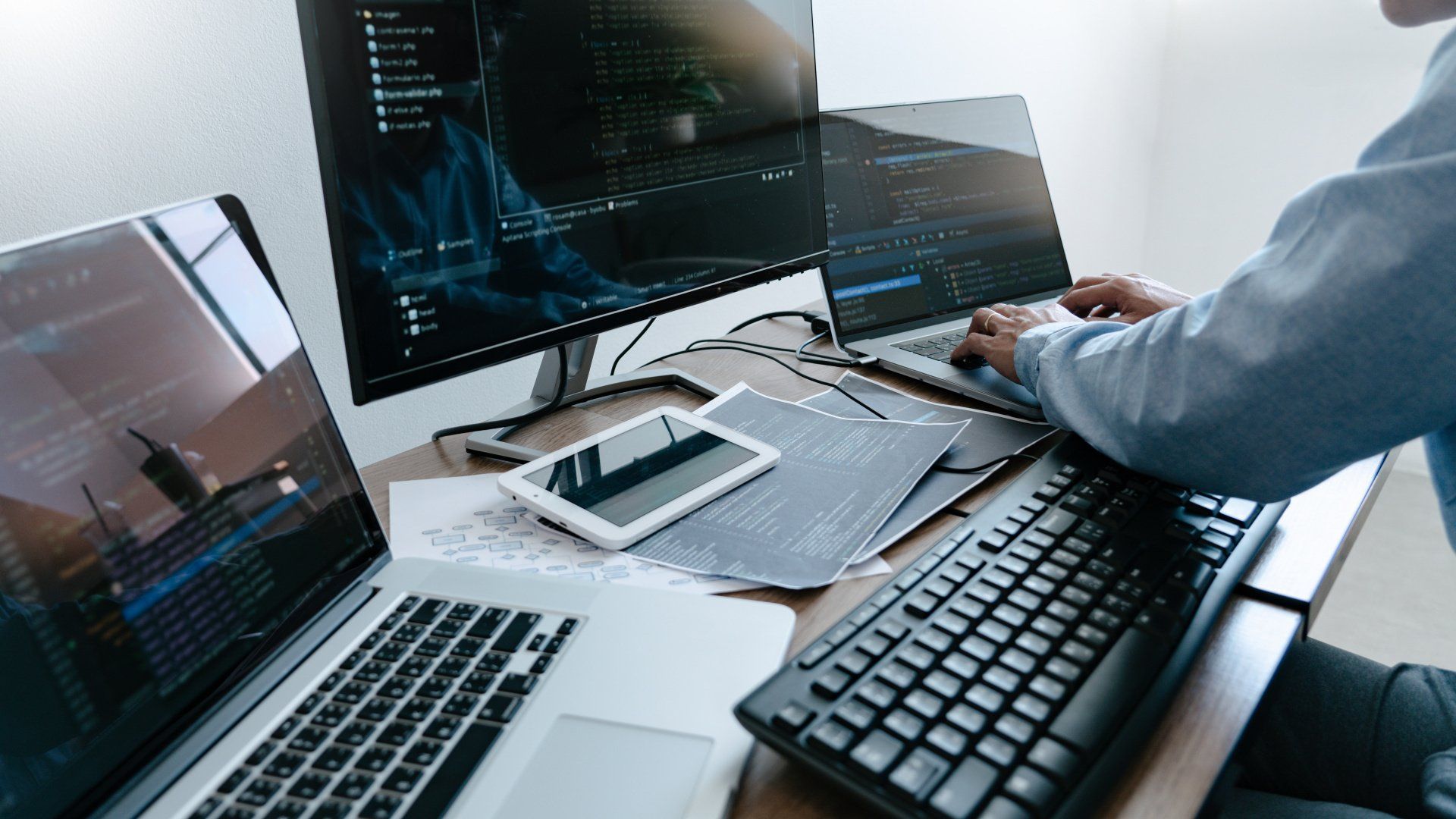 IT consultant with two laptops and monitor checking on Phishing attacks