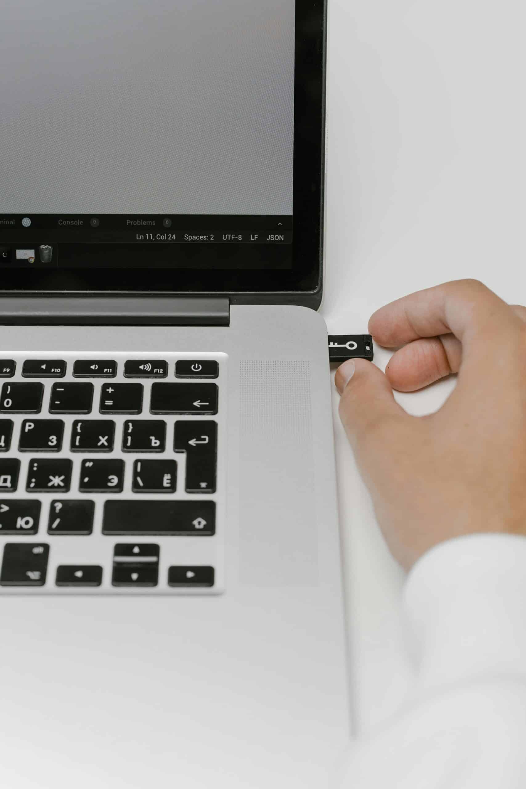 a USB stick being put into the port of a laptop to backup