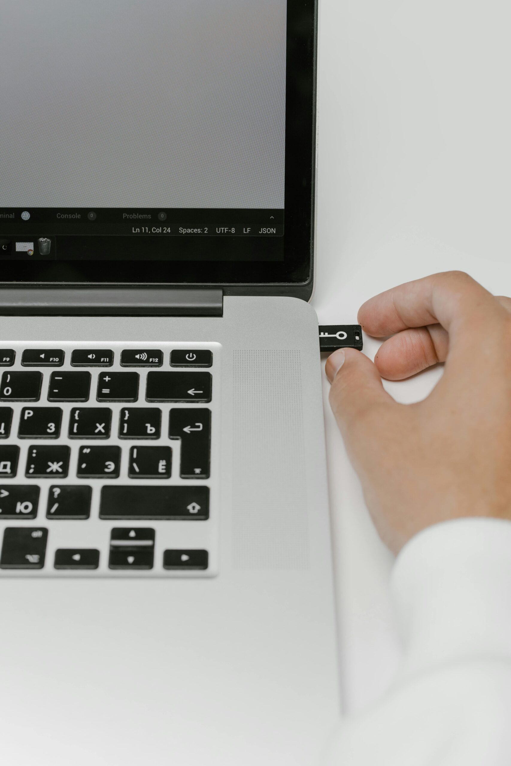 A hand inserting a USB stick into a laptop