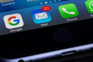 close up of iphone showing 20 messages in email inbox