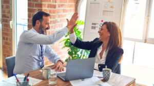 2 colleagues high-fiving over a good result.